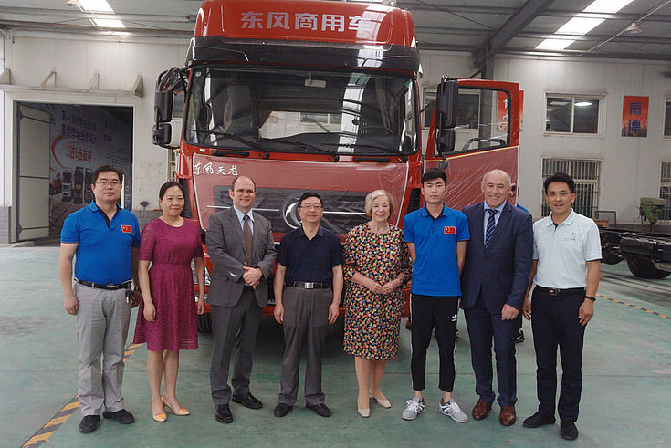 HSS-Vertreter mit Ausbildern und Lehrling vor einem Nutzfahrzeug der Firma Dongfeng.